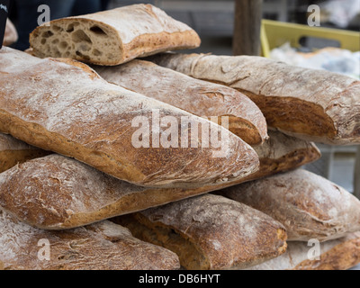 Laib Vollkornbrot gestapelt auf dem Markt. Große Brote von französischen Vollkornbrot gestapelt für den Verkauf auf dem Markt. Stockfoto