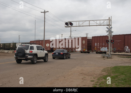 Güterwagen auf BNSF Güterzug fährt über Bahnübergang an der Perry Oklahoma USA Stockfoto