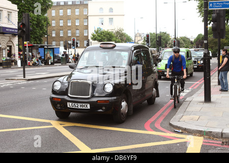 Londoner Straßenszene mit einem schwarzen Taxi Cab und Radfahrer. 4. Juli 2013 Stockfoto