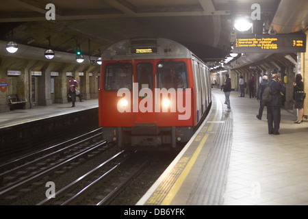 Juli 2013 - älterer Londoner U-Bahn-Stil, der einen Bahnhof einfährt. Stockfoto