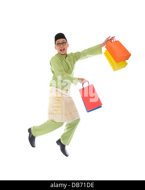 indonesische männlichen Einkaufs- und springen in Freude während Hari Raya Ramadan festival Stockfoto