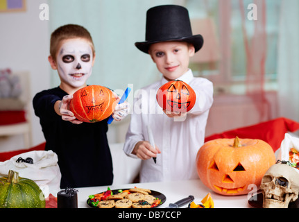 Foto von zwei unheimlichen jungen zeigen Halloween Kürbisse Stockfoto