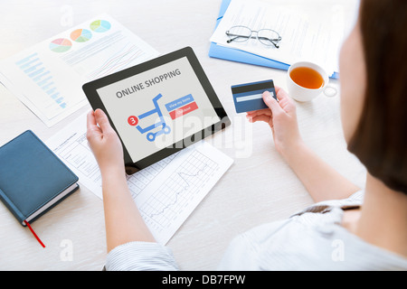 Kaukasische Geschäftsfrau am Schreibtisch im Büro und mit Kreditkarte und modernen digital-Tablette für Online-shopping Stockfoto