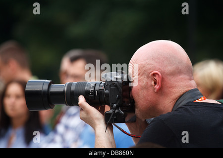 Fotografen unter Bild mit Dslr-Kamera mit Tele-Zoom-Objektiv. Stockfoto