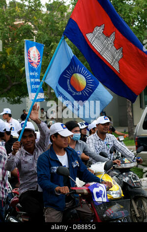 Phnom Penh, Kambodscha am 25. Juli 2013. Sam Rainsy Anhänger fahren durch die Straßen von Phnom Penh winken der kambodschanischen Flagge & die Flagge Kambodscha National Rescue Party [CNRP]. Sam Rainsy ist seit 2009 im Exil in Frankreich. Er war eine königliche Begnadigung gewährt, des Königs von Kambodscha & am 19. Juli 2013 wieder in Kambodscha. Bildnachweis: Kraig Lieb / Alamy Live News Stockfoto