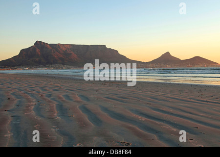 Blick vom Milnerton Strand bei Sonnenuntergang des Tafelbergs und Lions Head und Teufels Peak, Kapstadt Stockfoto