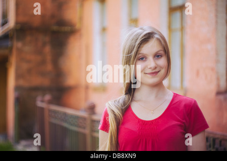 Blauäugige Mädchen in der Nähe von Grunge-Wand Stockfoto