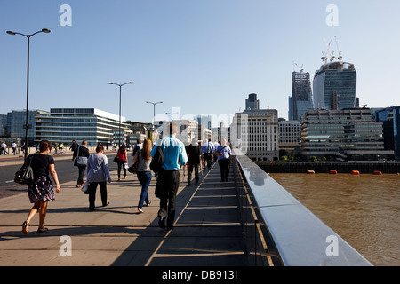 Pendler und Stadtarbeiter überqueren London Brücke Sie den Fluss Themse in den Morgen central London England UK Stockfoto