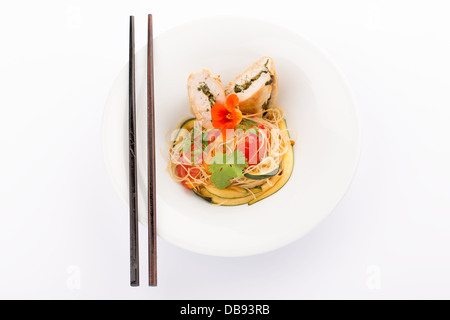 Asiatische Küche mit Stück gefüllte Hähnchen, Nudeln, Zucchini, Karotten und Tomaten. Stockfoto