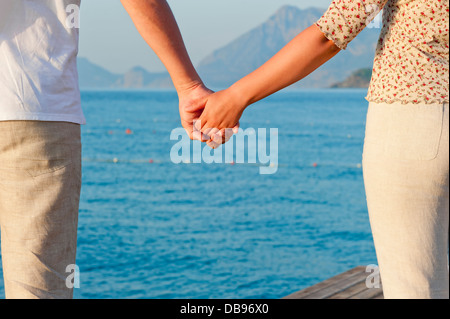 Liebendes Paar Hand in Hand auf dem Hintergrund des Meeres Stockfoto