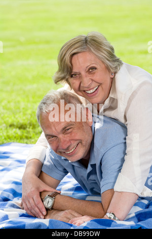 Aktiven Ruhestand Lachen älteres Paar im Grass liegen Stockfoto