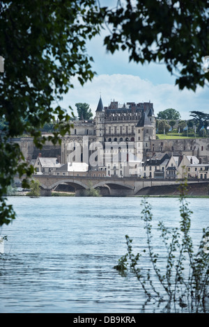 Ein Blick auf das Schloss, Brücke & Stadt von Amboise an der Loire, Frankreich aus über den Fluss Loire, umrahmt von Bäumen. Stockfoto