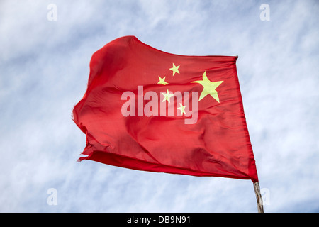 Chinesische Flagge winkt im Wind vor dem Hintergrund eines bewölkten Himmels in Sichuan, China Stockfoto
