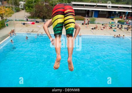 Ein Junge springt von einem Sprungturm im Freibad Lister Bad in Hannover, 26. Juli 2013. Foto: Sebastian Kahnert Stockfoto