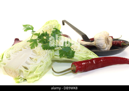 Spitzkohl mit Petersilie, Paprika und Zwiebeln auf einem hellen Hintergrund Stockfoto