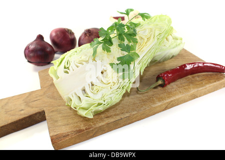 Spitzkohl mit Petersilie, Knoblauch, Paprika und Zwiebeln auf einem hellen Hintergrund Stockfoto
