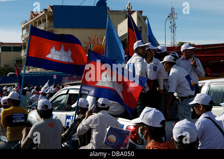 Phnom Penh, Kambodscha am 26. Juli 2013. Führer der Sam-Rainsy-Partei sorgfältig die Rallye als kambodschanischen Fahnen Welle im Vordergrund. Sam Rainsy ist seit 2009 im Exil in Frankreich. Er war eine königliche Begnadigung gewährt, des Königs von Kambodscha & am 19. Juli 2013 wieder in Kambodscha. Bildnachweis: Kraig Lieb / Alamy Live News Stockfoto