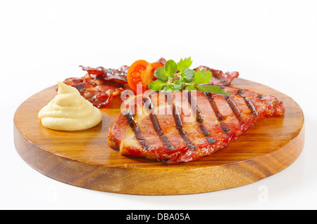 Scheiben von geräuchertem Schweinenacken und Senf Stockfoto