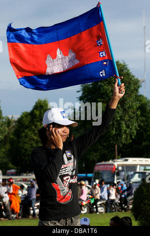 Phnom Penh, Kambodscha am 26. Juli, 2013. Sam Rainsy Unterstützer winken die kambodschanischen Flagge und über sein Handy Telefon, während er die Rallye in Phnom Penh überblickt. Sam Rainsy hat sich in selbst-Exil in Frankreich seit 2009. Er eine königliche Begnadigung durch den König von Kambodscha gewährt wurde und kehrte am 19. Juli 2013 in Kambodscha. Credit: Kraig Lieb/Alamy leben Nachrichten Stockfoto