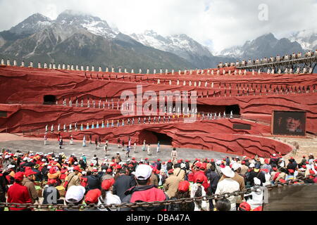 Gruppen von Touristen tragen rote und weiße Kappen Uhrenproduktion präsentiert lokale Kultur von Regisseur Zhang Yimou (am Bildschirm auf der rechten Seite) auf dem Jade Drachen Berg, in der Nähe der touristischen Stadt von Lijiang in der südwestlichen chinesischen Provinz Yunnan, 15. Mai 2009. Foto: Bill Smith/Dpa (Zu Dpa Chinesische Touristen Sollen Bessere Manieren Lernen Vom 25.07.2013) Stockfoto