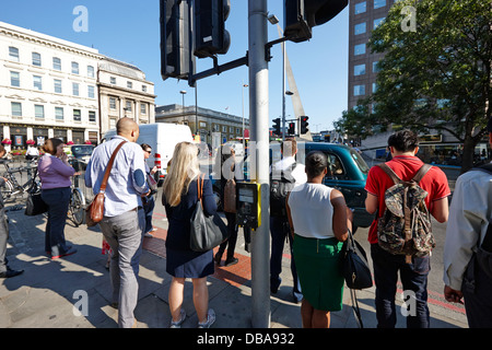 am frühen Morgen Pendler warten darauf, überqueren Sie die Straße Fußgängerüberweg London England UK Stockfoto