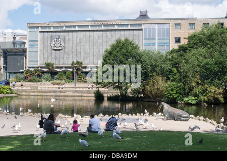 Familie Fütterung Vögel Sunderland Mowbray Park mit Museum und die Kunstgalerie im Hintergrund, Nord-Ost-England Stockfoto