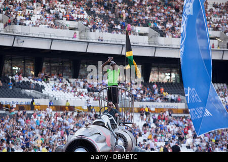 London, UK. 26. Juli 2013. Usain Bolt betritt Olympiastadion auf einer Rakete Gruß Fans. 100m Olympic Champion Usain Bolt steht neben der jamaikanische Flagge auf einer Rakete. Geburtstag Spiele britischen Leichtathletik in London. Foto: Credit: Rebecca Andrews/Alamy Live-Nachrichten Stockfoto