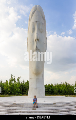 Kleiner Junge saß vor der Traum, eine 20m hohe Skulptur in Bold Waldpark, Sutton Manor Zeche, St Helens, Merseyside, England Stockfoto