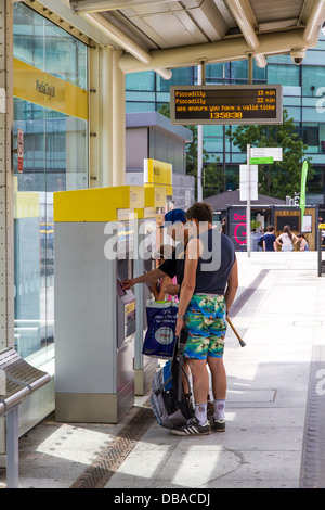 Menschen den Kauf von Fahrkarten aus Manchester Metrolink Fahrkartenautomaten an MediaCity, Salford Quays. Stockfoto