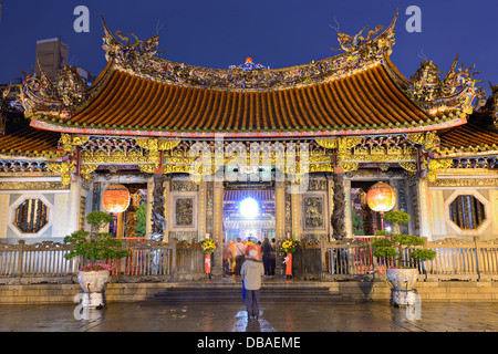 Touristen am Mengjia Longshan Tempel in Taipei, Taiwan in der Nacht. Stockfoto