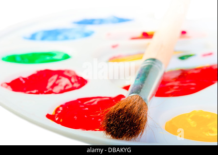 Des Künstlers Pinsel auf einer weißen Palette mit Farben Stockfoto