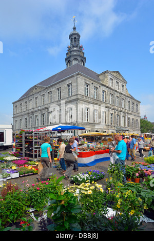 Der Marktplatz von Maastricht wird von den Blumenhändlern des historischen Rathauses auf der Arbeit übersehen und die Käufer sehen Blumen zum Verkauf, sonniges Limburg Niederlande Stockfoto