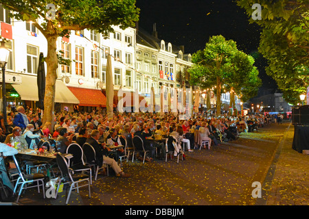 In der Straßenszene am Vrijthof Square in Maastricht City können Sie das Orchester von André Rieu beobachten, das am Sommerabend ein Musikkonzert in der EU aufführt Stockfoto