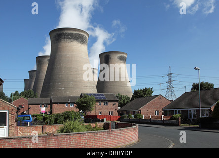 Eine Wohnstraße überschattet die 8 115m hohen Kühltürme von Ferrybridge C-Kraftwerk in West Yorkshire, Großbritannien. Stockfoto