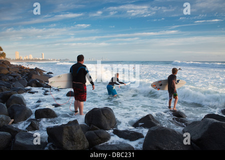 Surfer über Felsen klettern, Surfen in Burleigh Heads zu erreichen. Gold Coast, Queensland, Australien Stockfoto