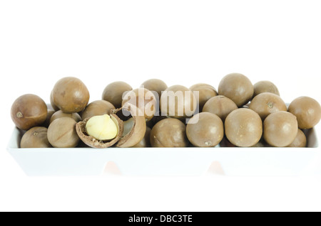 Macadamia in Schüssel weiß auf weißem Hintergrund hautnah Stockfoto