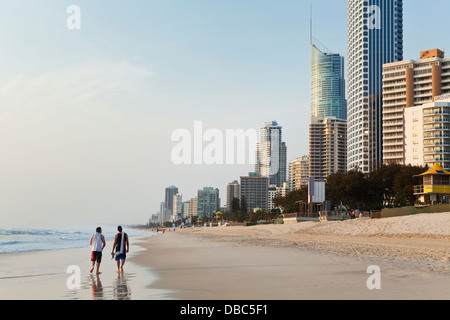 Touristen am Strand mit Skyline bei Surfers Paradise in der Morgendämmerung. Gold Coast, Queensland, Australien Stockfoto