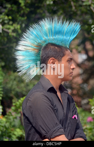 Profil-Porträt eines jungen Mannes mit einem bunten blauen Mohawk Haarschnitt am Union Square Park in New York City Stockfoto
