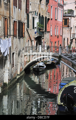 Kleinen Kanal mit Brücke und Boote und Wäsche aufhängen auf Linie in Venedig, Venezia, Veneto, Italien, Europa Stockfoto