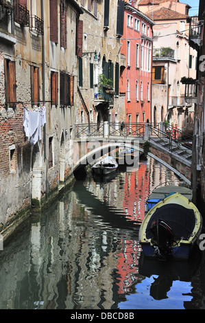 Kleinen Kanal mit Brücke und Boote und Wäsche aufhängen auf Linie in Venedig, Venezia, Veneto, Italien, Europa Stockfoto