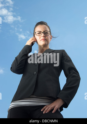 Eine seriöse Geschäftsfrau, die im Freien ein Smartphone benutzt Stockfoto