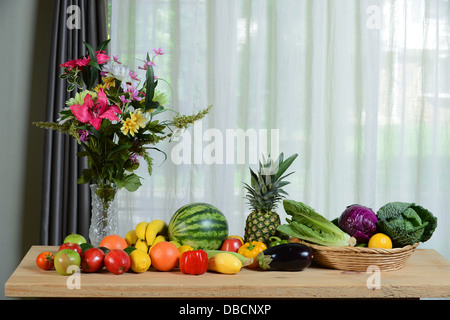 Auswahl an frischem Obst und Gemüse auf Holztisch mit Fenster Stockfoto