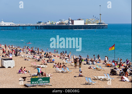 Urlauber entspannen Sie im Sonnenschein am Strand von Brighton East Sussex England UK Stockfoto