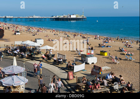 Urlauber entspannen Sie im Sonnenschein am Strand von Brighton East Sussex England UK Stockfoto