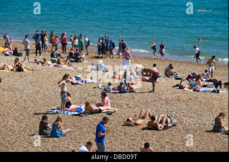 Urlauber entspannen Sie im Sonnenschein am Strand von Brighton East Sussex England UK Stockfoto