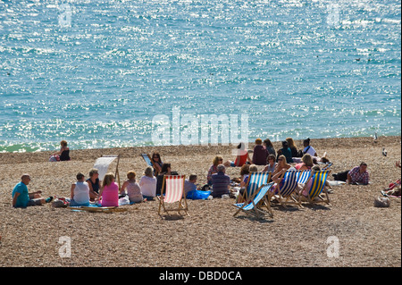Urlauber entspannen Sie im Sonnenschein am Strand von Brighton East Sussex England UK Stockfoto