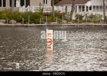 Abgebildet ist eine Boje Achtung Bootsfahrer zu verlangsamen an Sebago See im Süden Casco, Maine Stockfoto