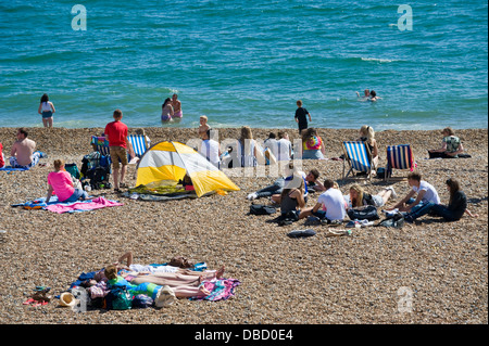 Urlauber entspannen Sie im Sonnenschein am Strand von Brighton East Sussex England UK Stockfoto