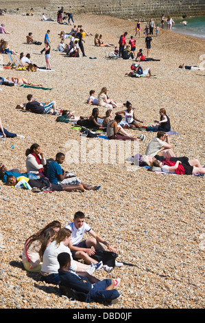Urlauber entspannen Sie im Sonnenschein am Strand von Brighton East Sussex England UK Stockfoto