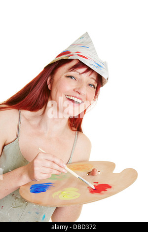 Glückliche Frau arbeiten mit Pinsel, Palette und Maler Hut mischen Stockfoto